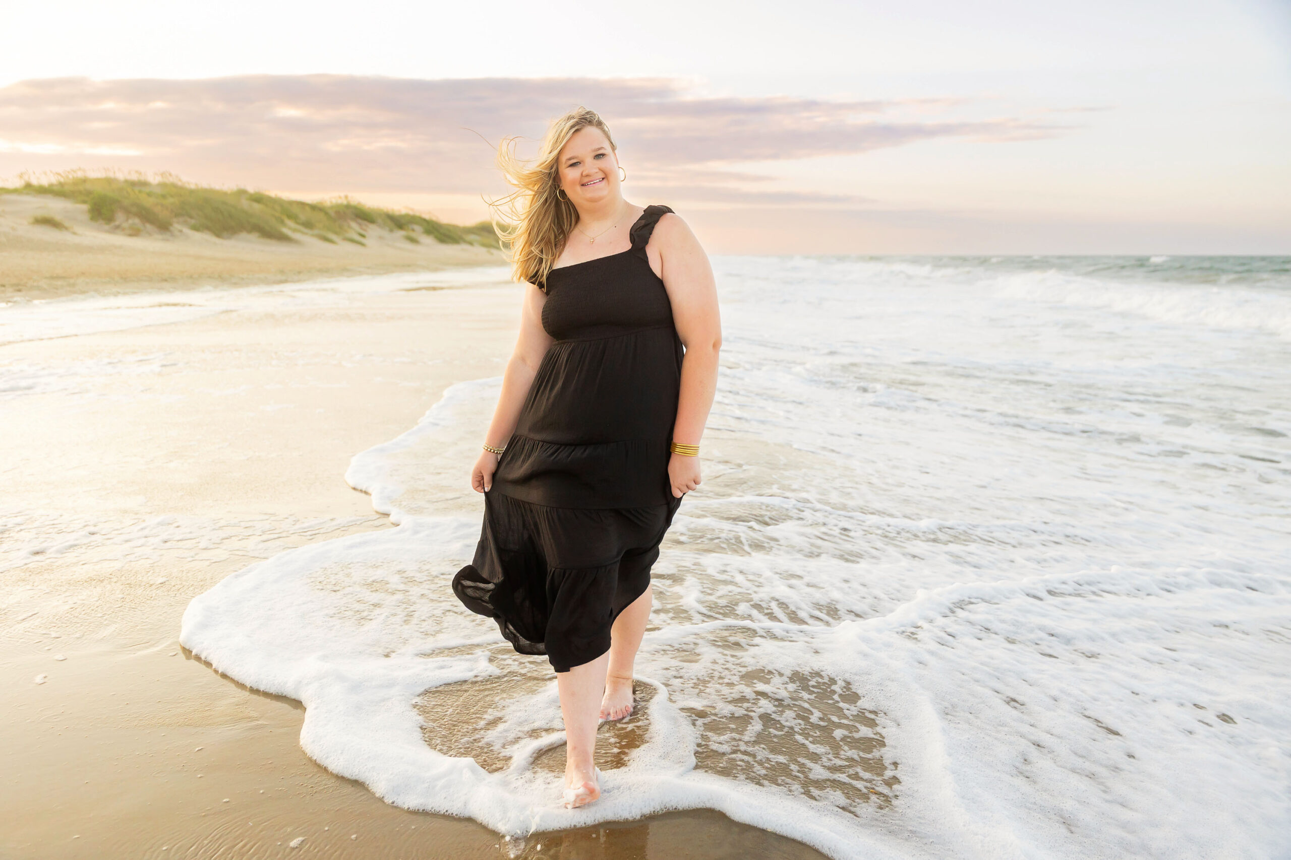 Soft, natural portrait of Mattison with moody skies and the ocean in the background during her OBX senior session.