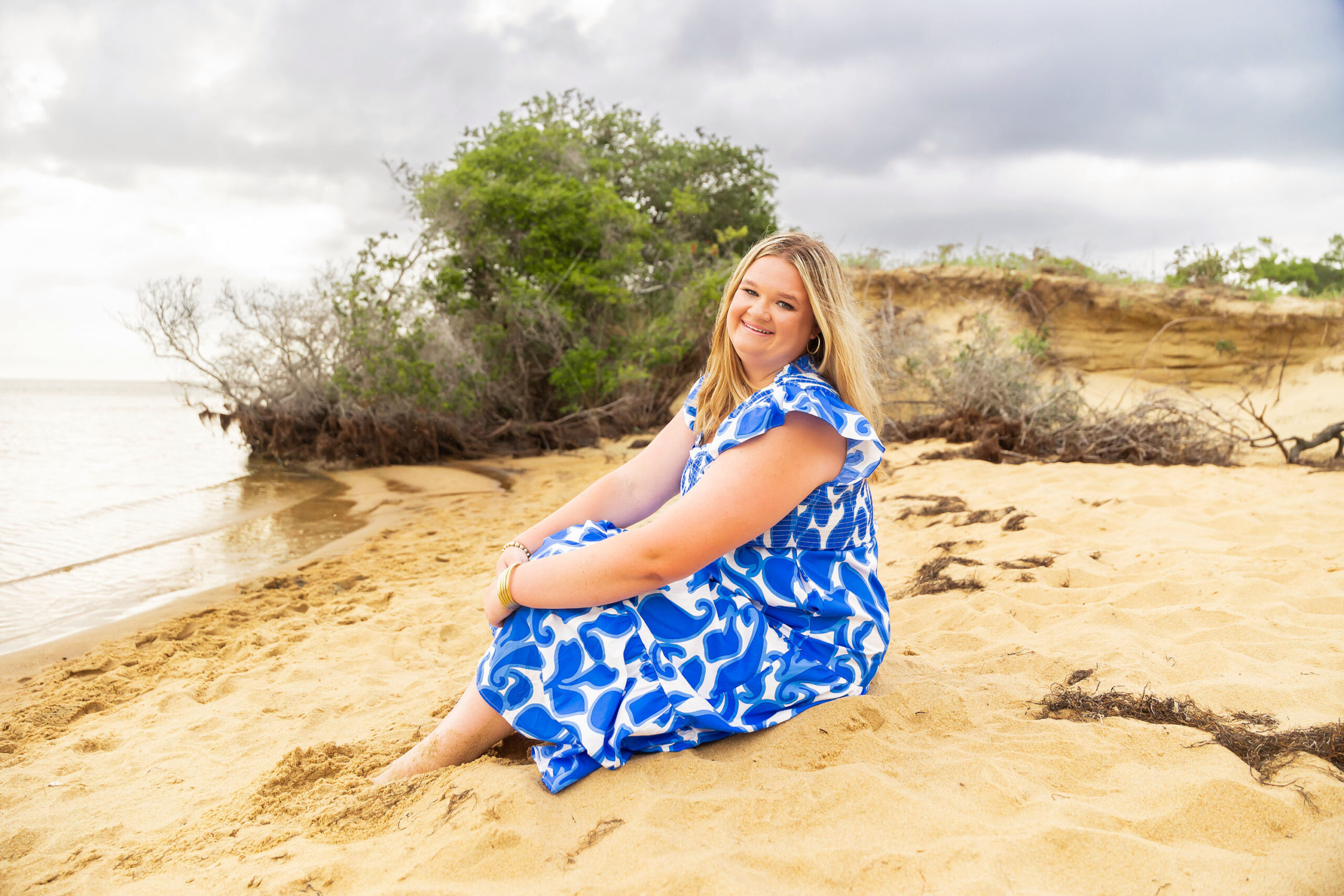 Soft, natural portrait of Mattison with moody skies and the ocean in the background during her OBX senior session.