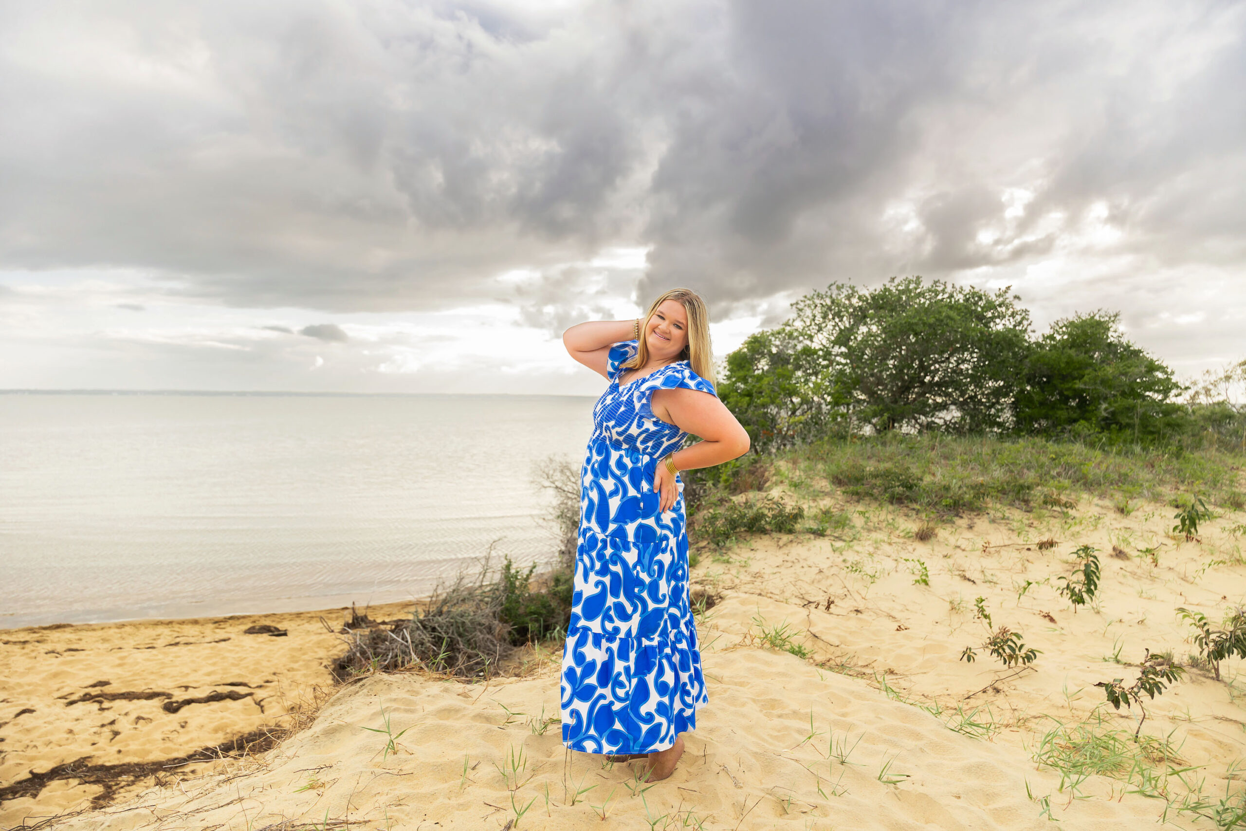 Soft, natural portrait of Mattison with moody skies and the ocean in the background during her OBX senior session.