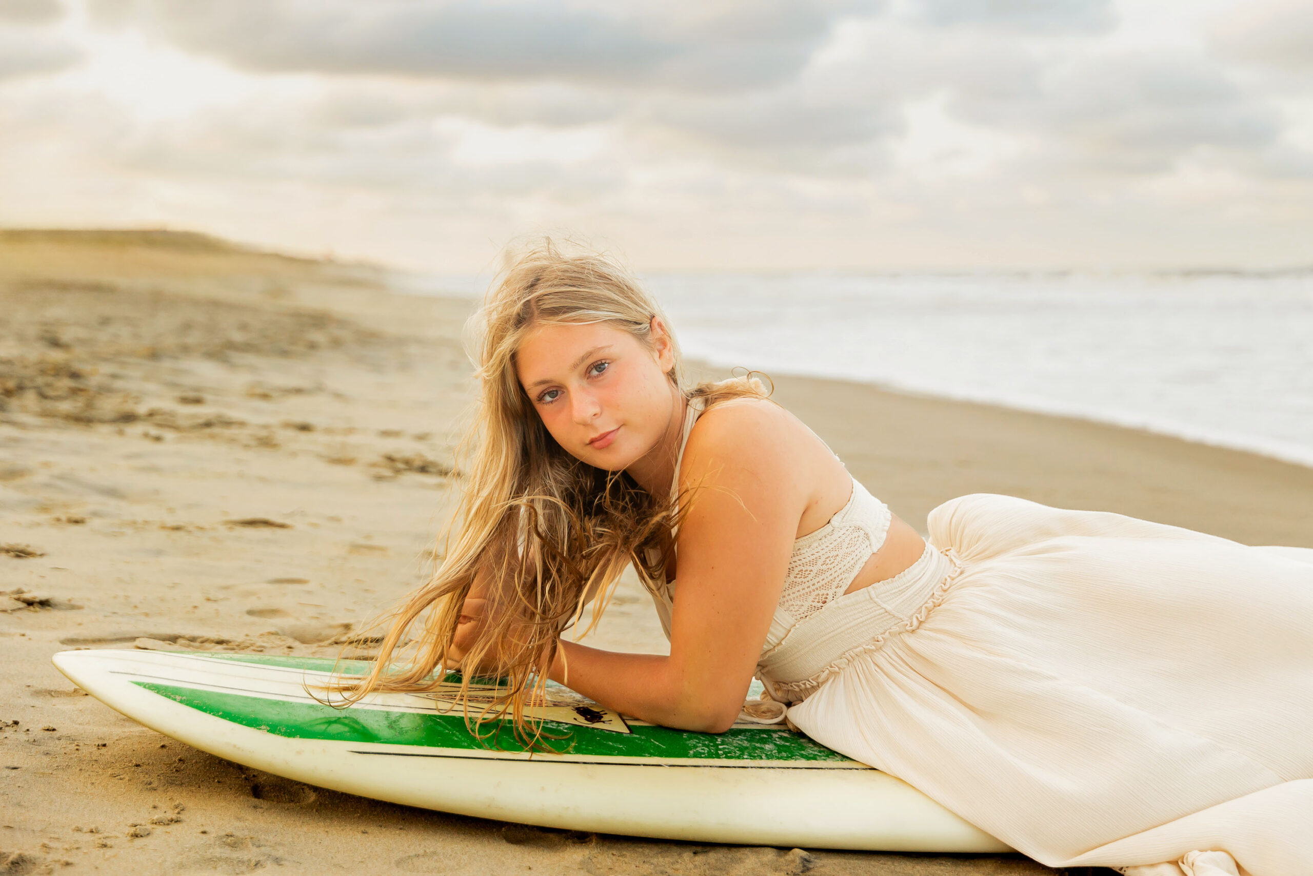 Senior portraits with surfboard on the Outer Banks beach
