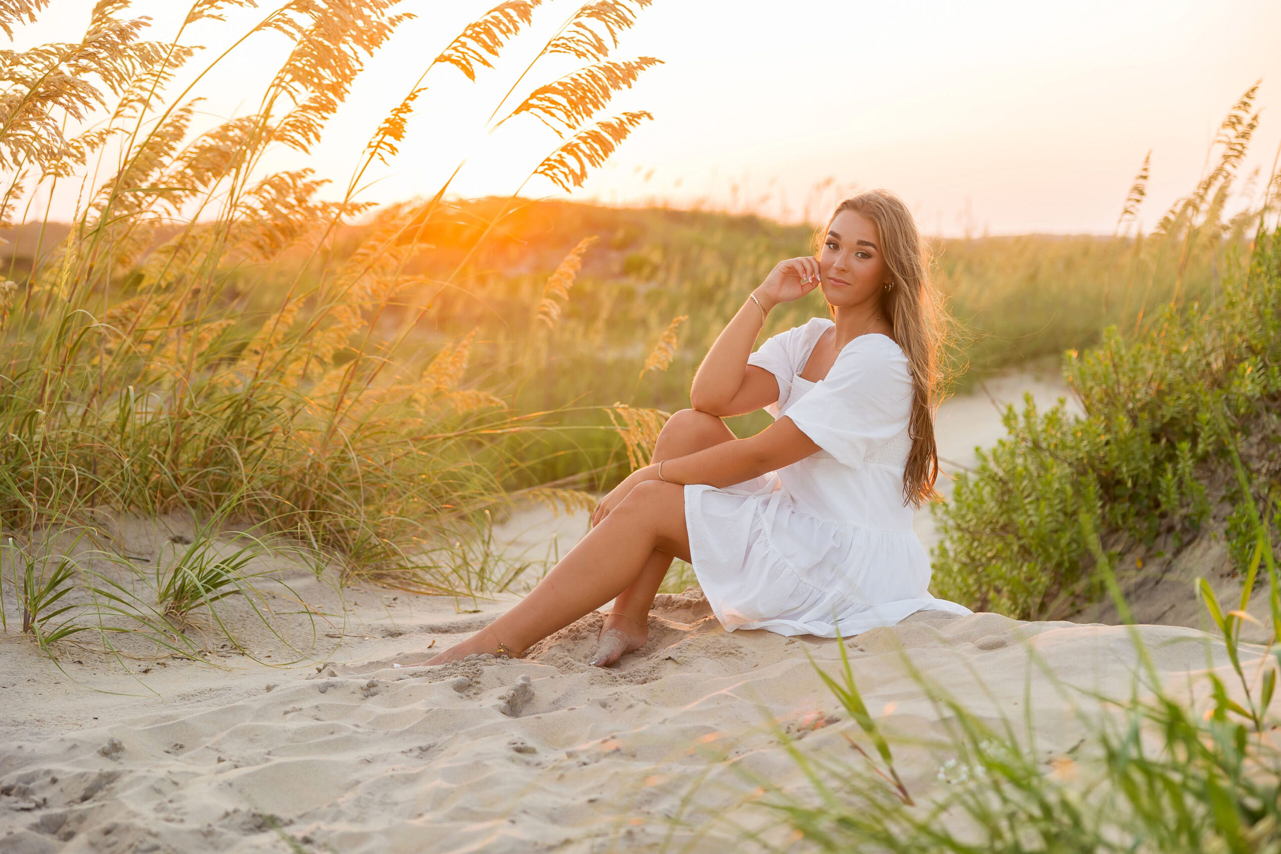 High school senior posing at golden hour on Coquina Beach in the Outer Banks for senior portraits.