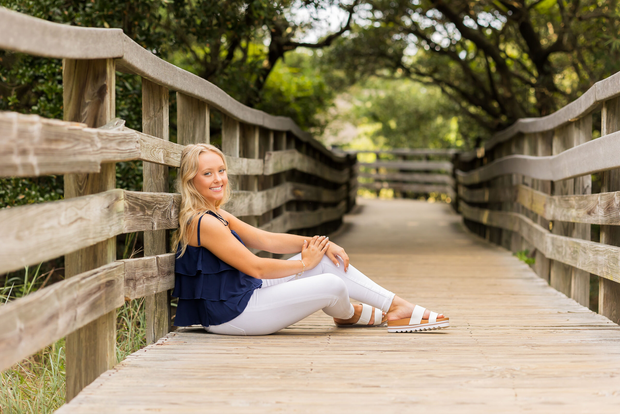 Senior girl standing on boardwalk at Jockey’s Ridge in Nags Head for Outer Banks senior portraits