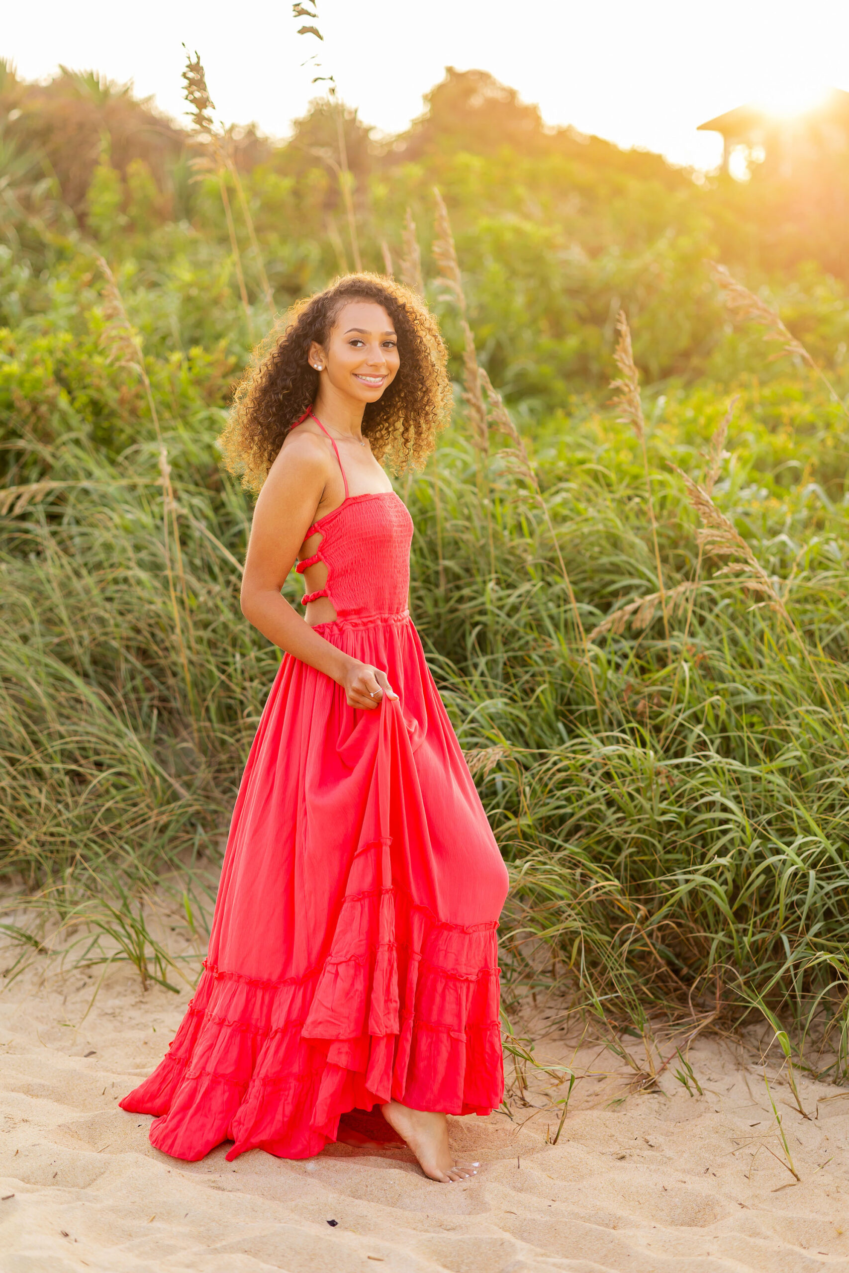 High school senior girl standing beside Nags Head Fishing Pier during Outer Banks senior photo session.