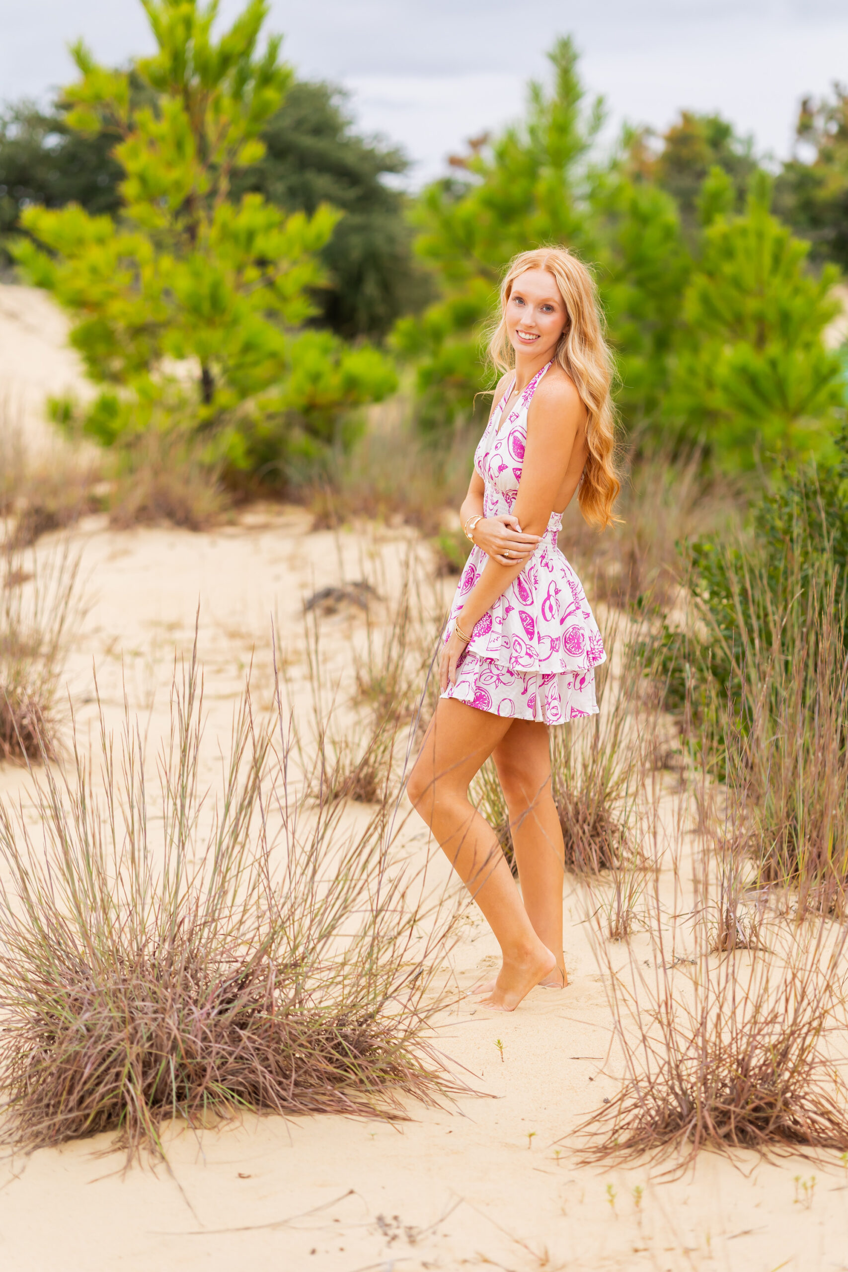 Senior portrait with soft golden hour lighting on the dunes at Jockey’s Ridge OBX.