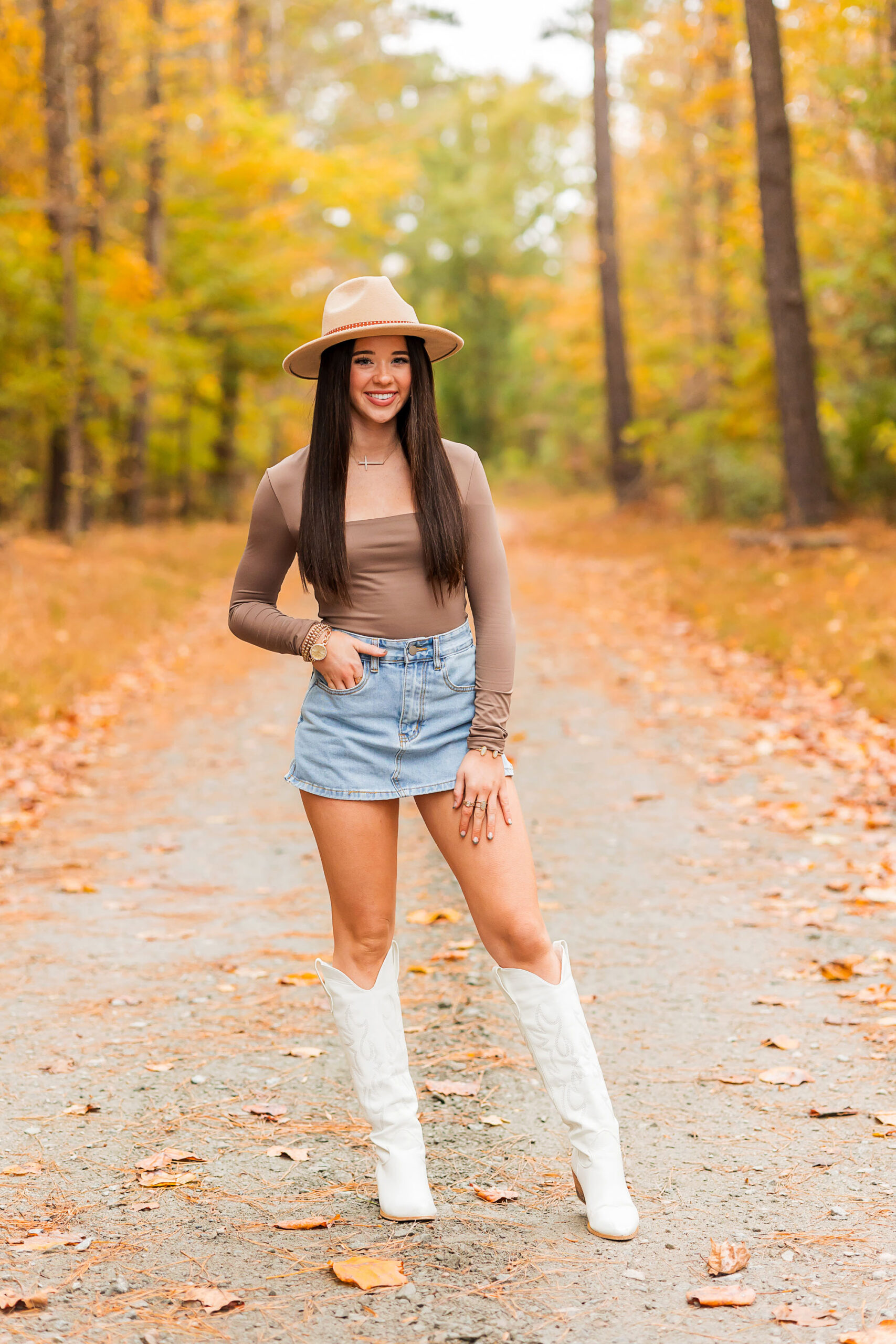 Senior girl enjoying her fall senior session in Eastern North Carolina with golden leaves in the background.