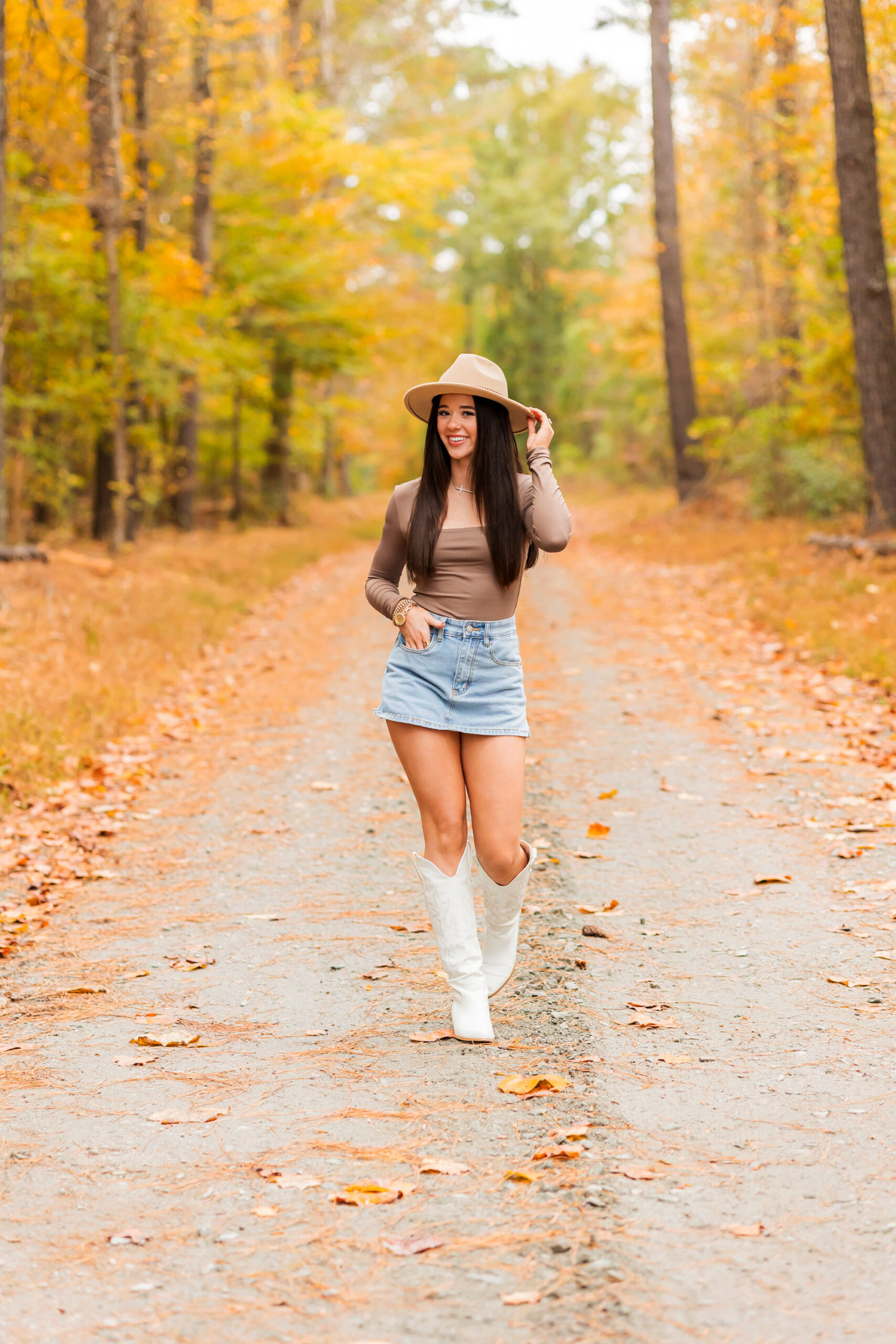 Senior girl enjoying her fall senior session in Eastern North Carolina with golden leaves in the background.