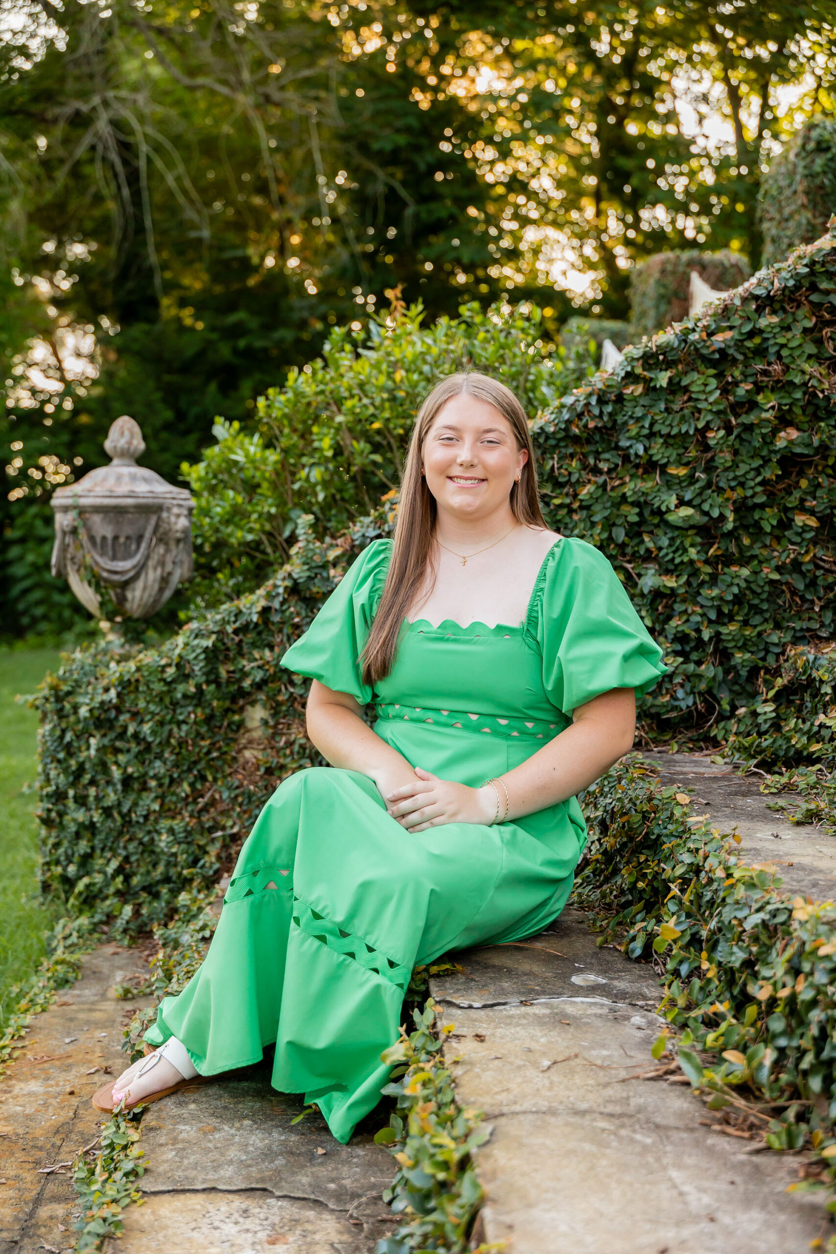Emily’s summer senior portrait in Downtown Edenton, wearing a green flowy dress along the tree-lined sidewalk, photographed by Sarah Hilts Photography.
