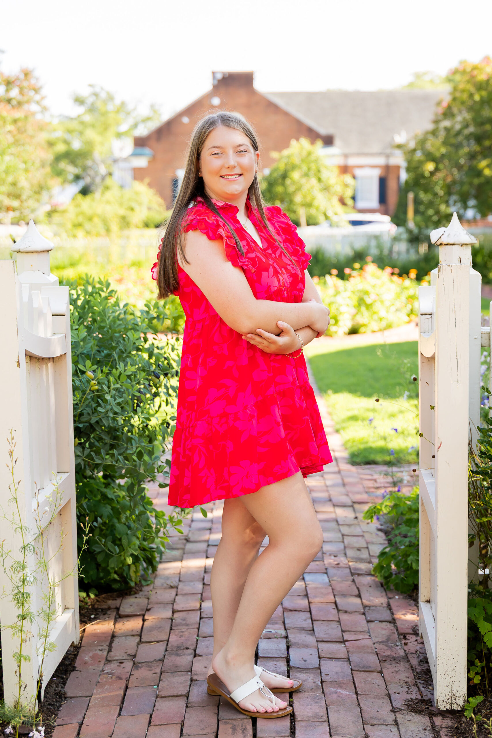 Downtown Edenton senior portraits of Emily from Currituck High School, surrounded by bright summer flowers during her June photo session.