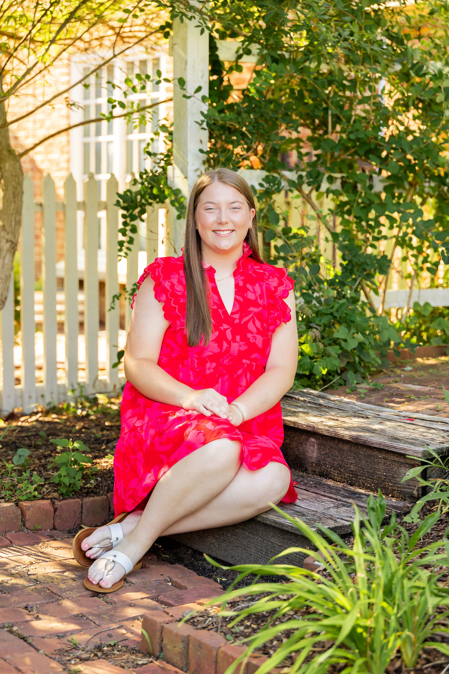 Downtown Edenton senior portraits of Emily from Currituck High School, surrounded by bright summer flowers during her June photo session.