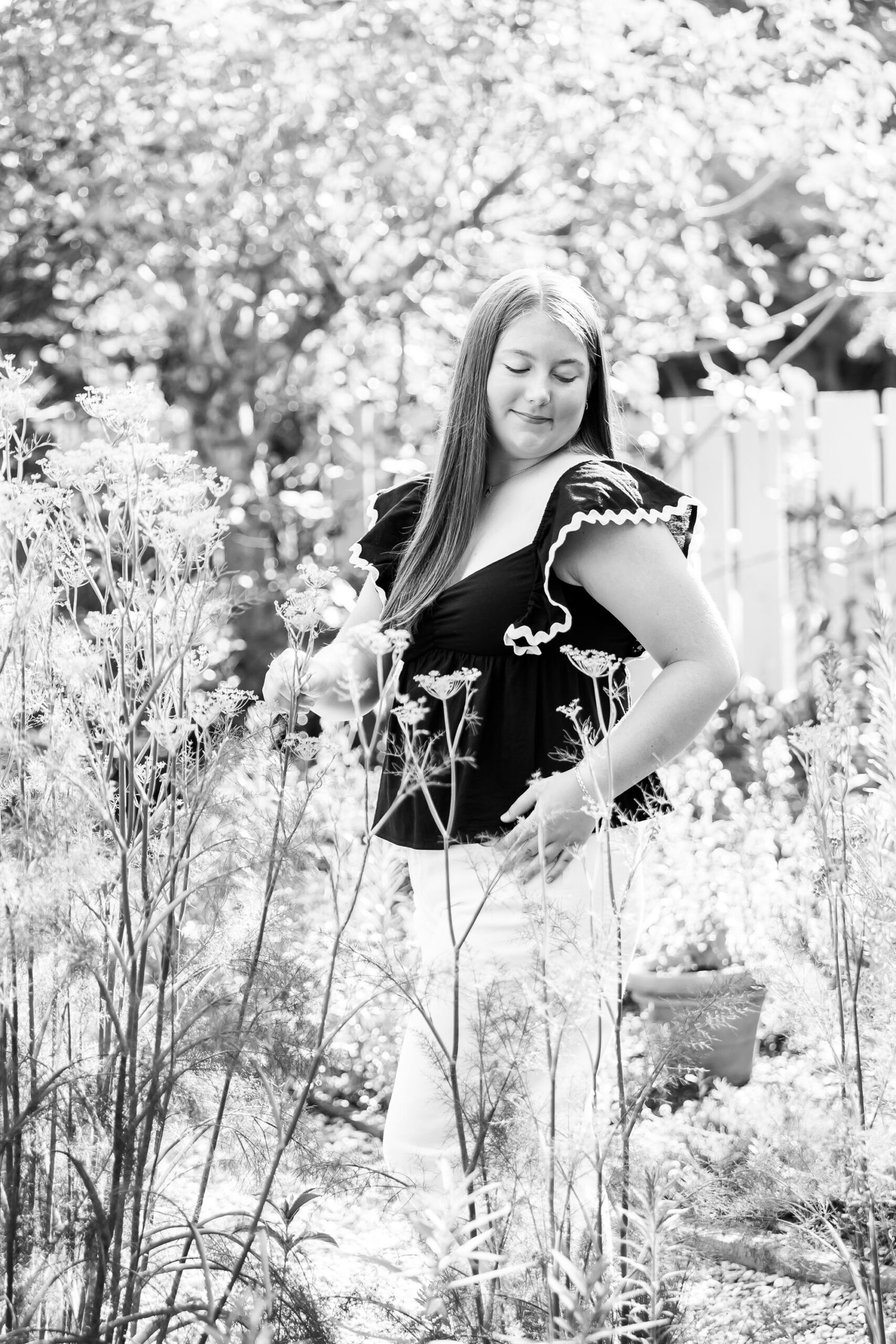 Downtown Edenton senior portraits of Emily from Currituck High School, surrounded by bright summer flowers during her June photo session.