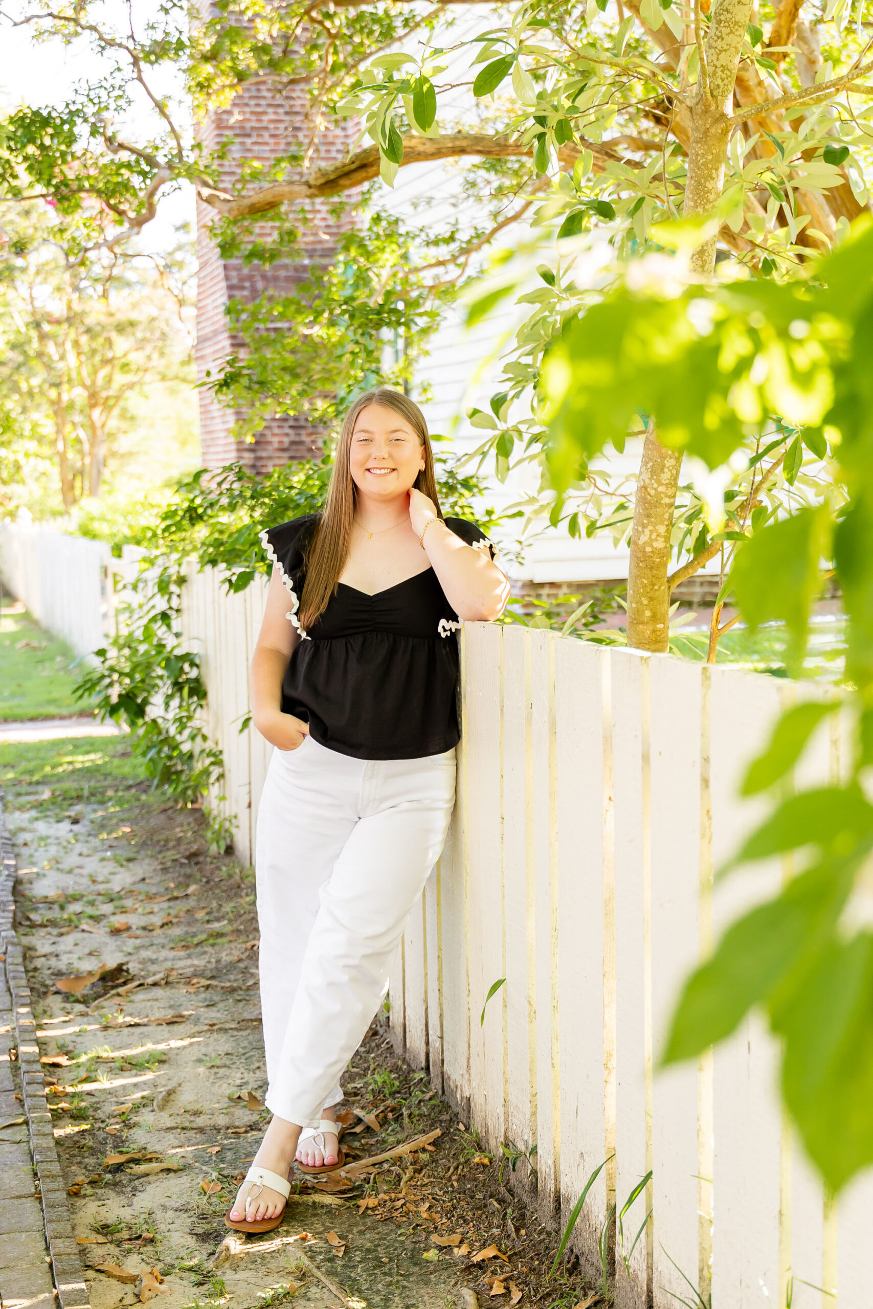 Downtown Edenton senior portraits of Emily from Currituck High School, surrounded by bright summer flowers during her June photo session.