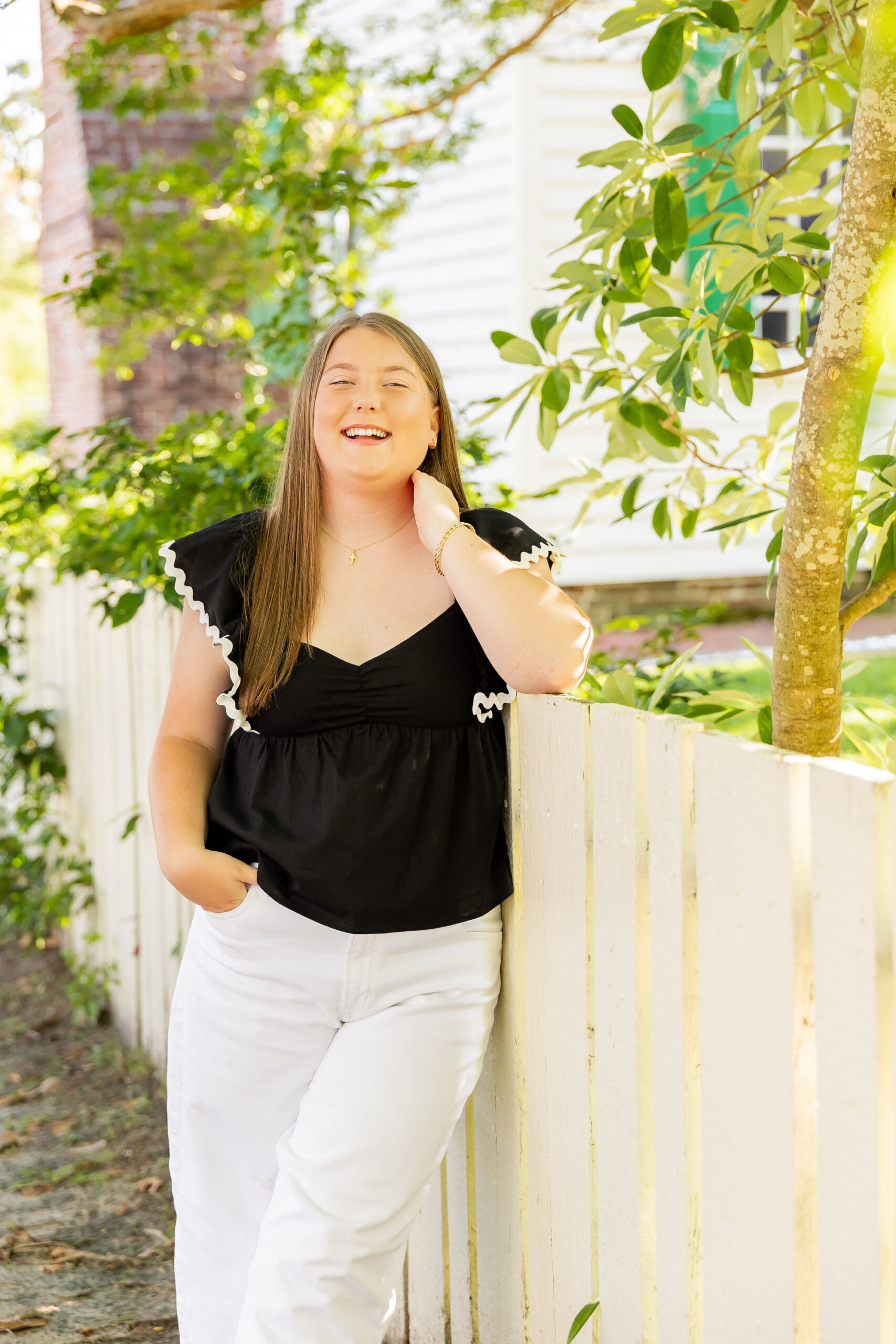 Downtown Edenton senior portraits of Emily from Currituck High School, surrounded by bright summer flowers during her June photo session.