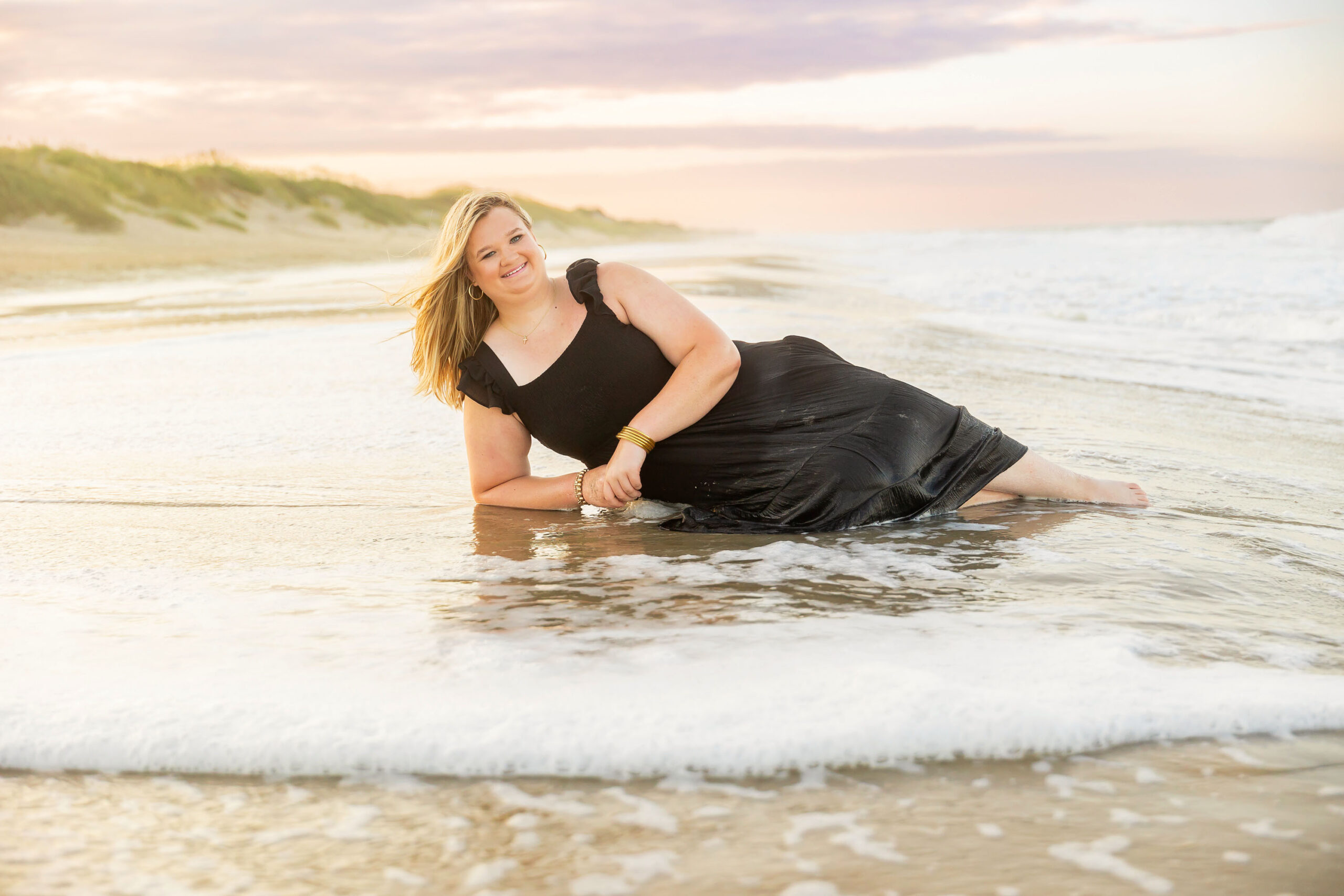 Soft, natural portrait of Mattison with moody skies and the ocean in the background during her OBX senior session.