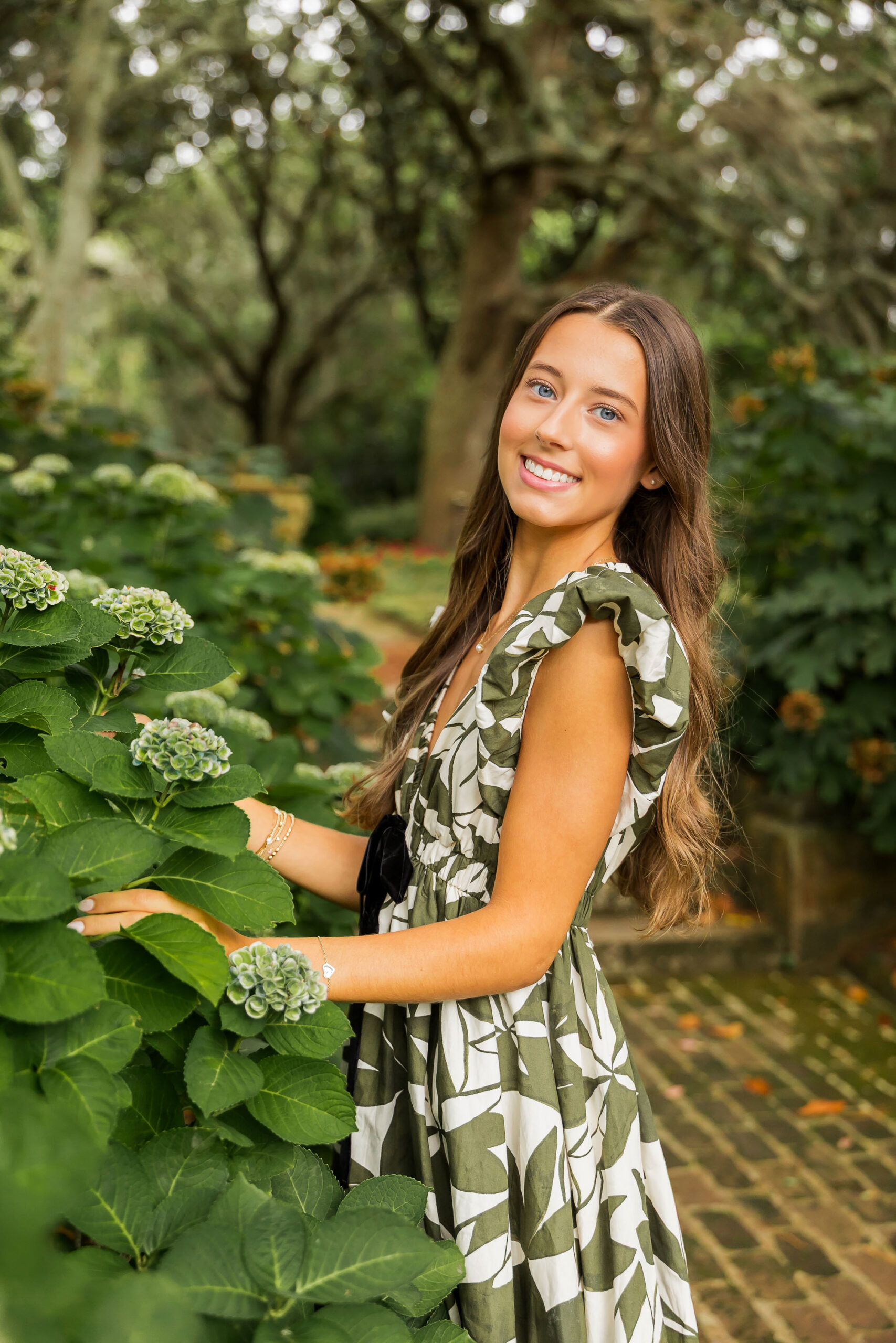 Senior girl in green dress at Elizabethan Gardens in Manteo North Carolina