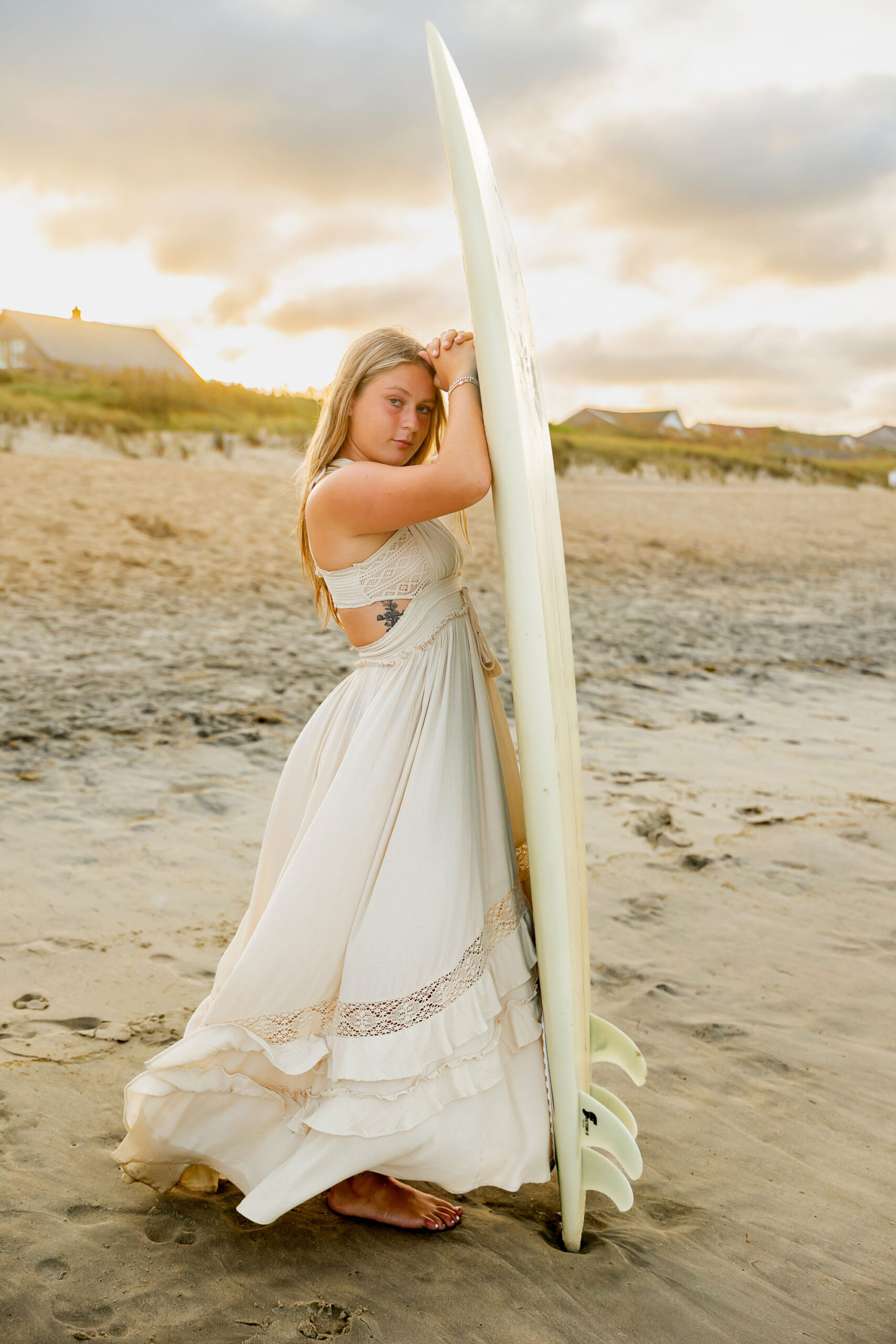 Senior portraits with surfboard on the Outer Banks beach