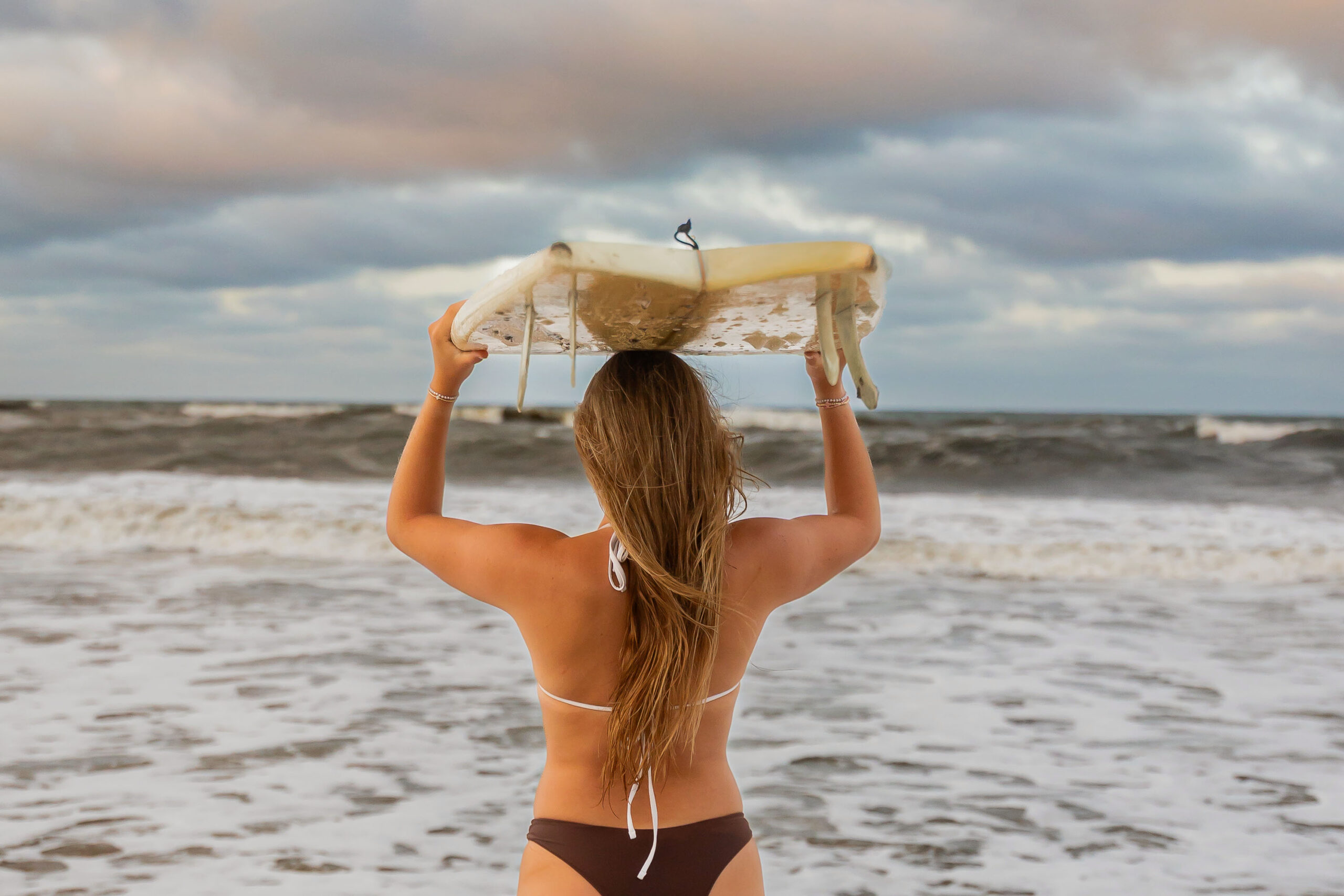 Senior portraits with surfboard on the Outer Banks beach